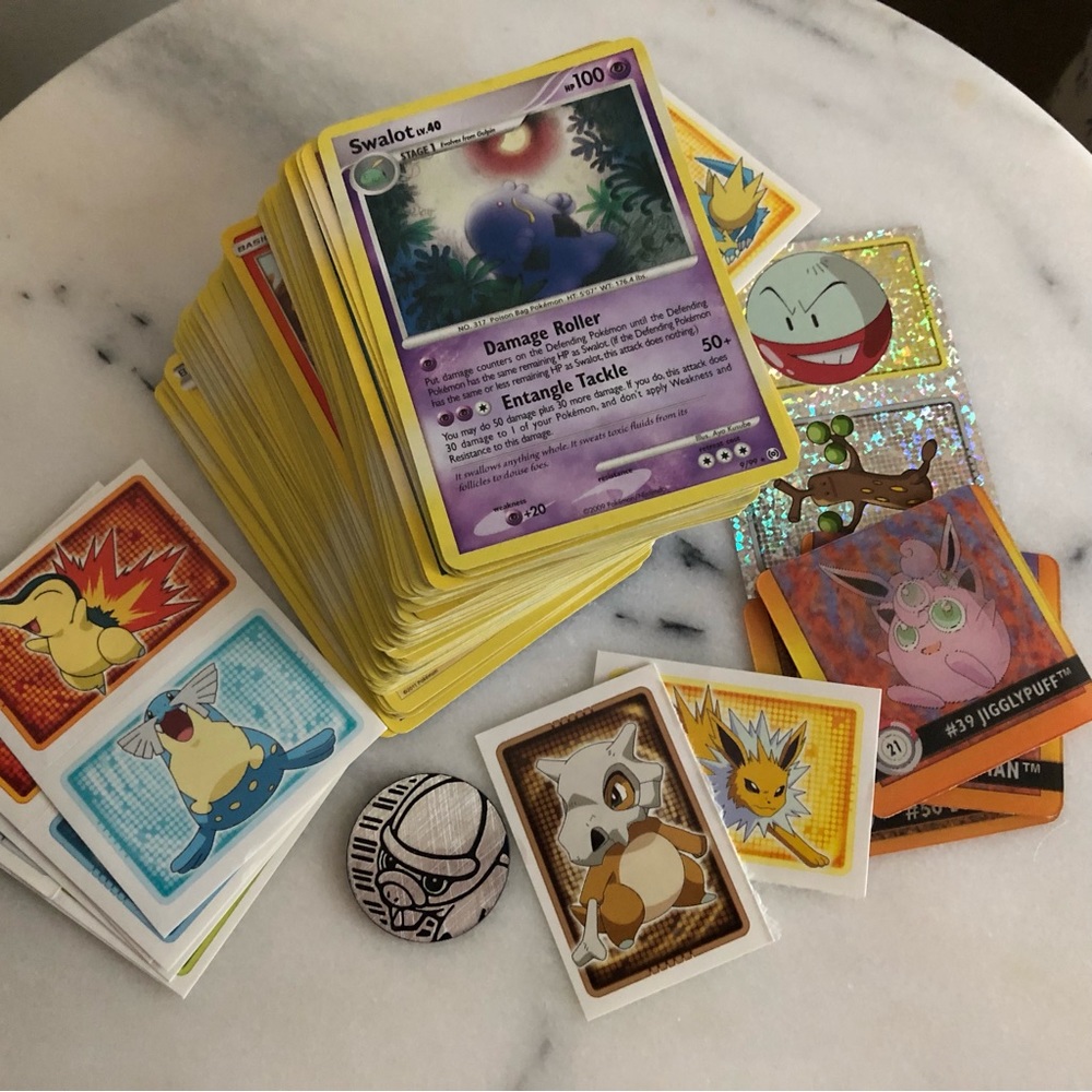 Bundle of 100+ Pokémon cards with stickers and collectible items